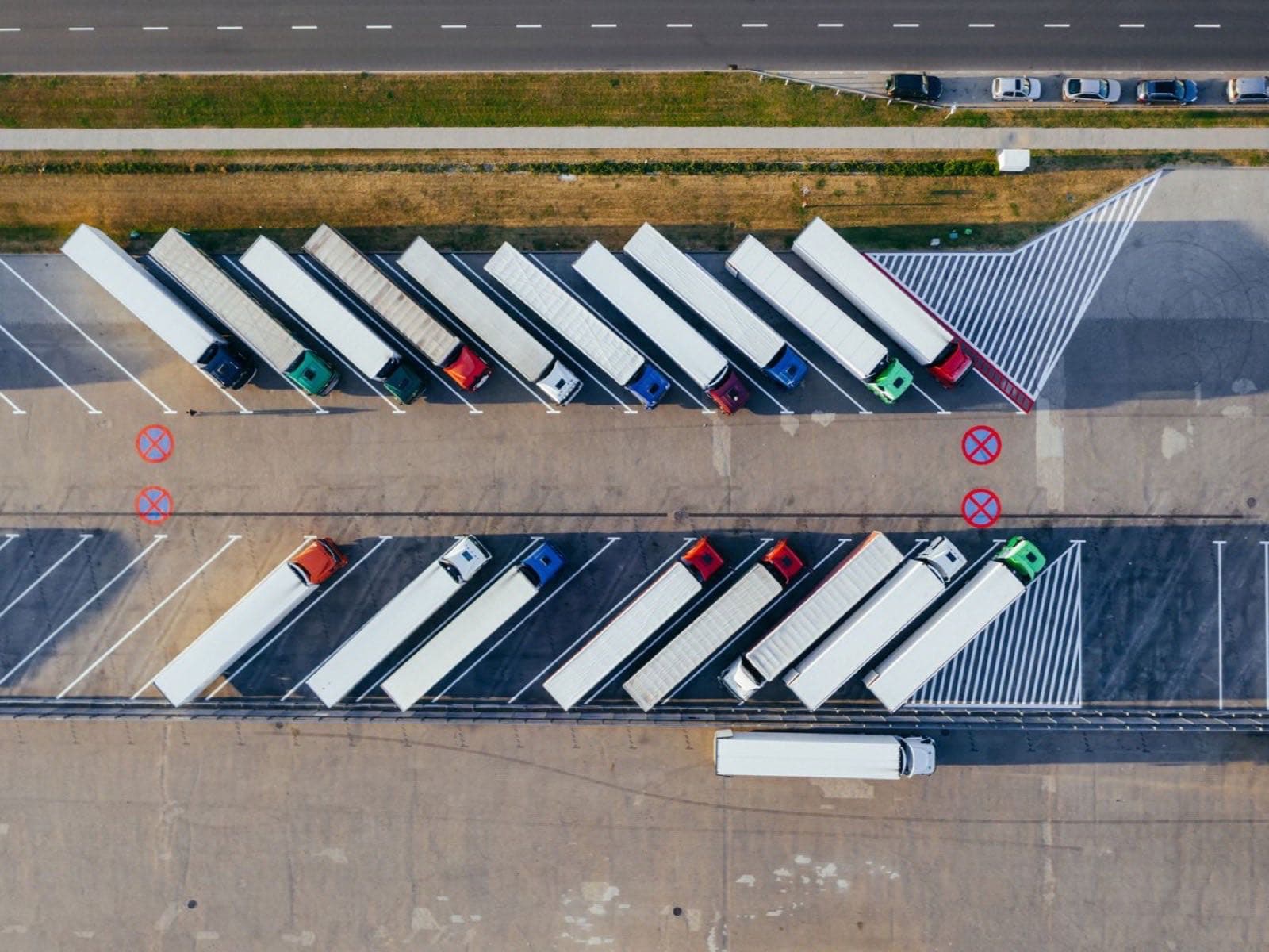 Row of parked trucks including reefers, dry vans, and flatbeds