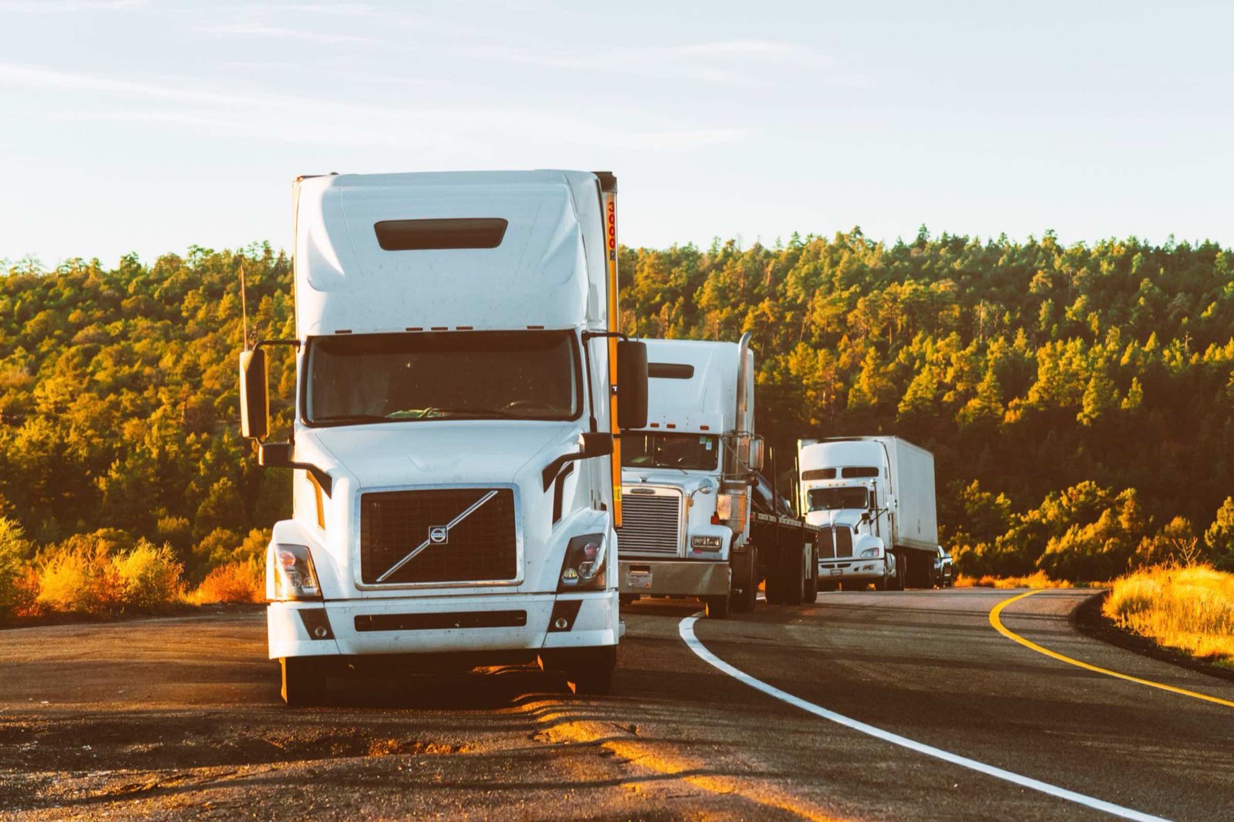 Semi truck driving on an open highway at golden hour