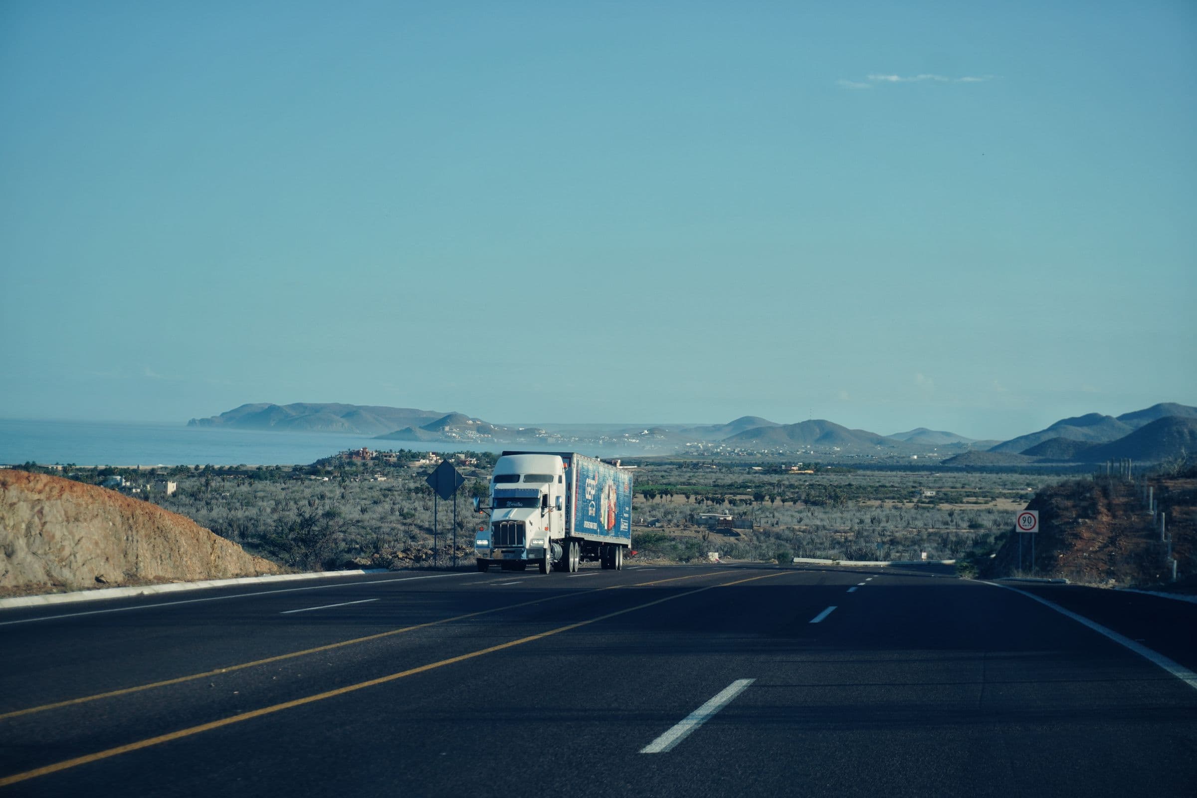 Semi truck on an open interstate at sunrise